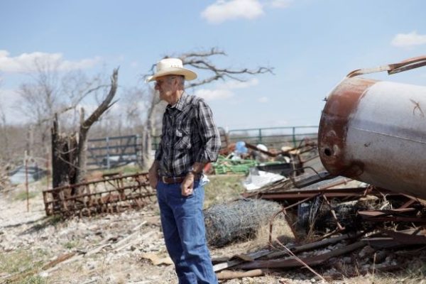 Carl looking at the damage done to his farm because of a tornado