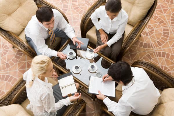 four adults discussing insurance while meeting for coffee