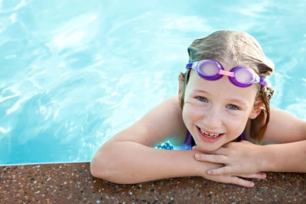 young girl smiling in a swimming pool