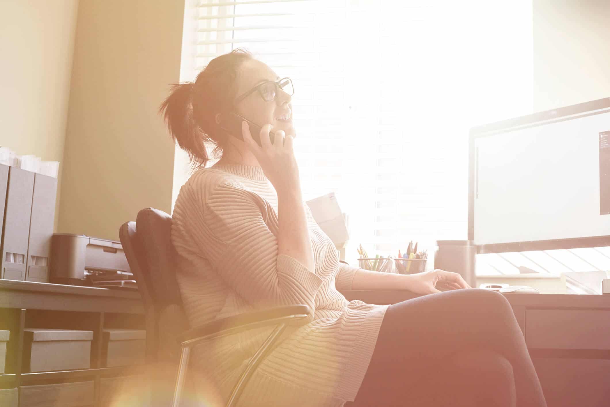woman on the phone sitting in home office