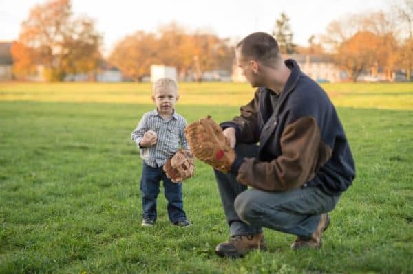 father teaches his young son how to play baseball
