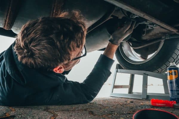 Mechanic repairing a car from underneath the vehicle