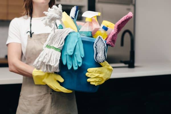 Woman holding bucket of cleaning supplies